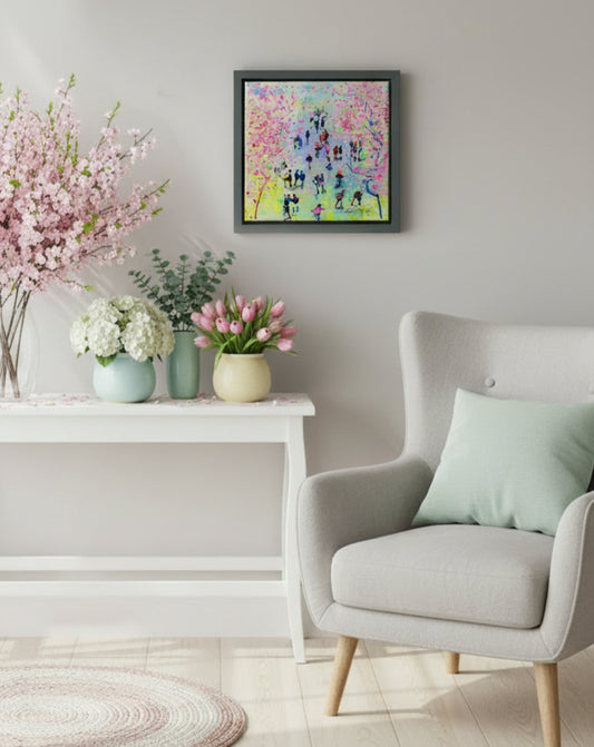Living room with a gray armchair, floral arrangements, and a colorful abstract painting, titled Blossom Time, on the wall.