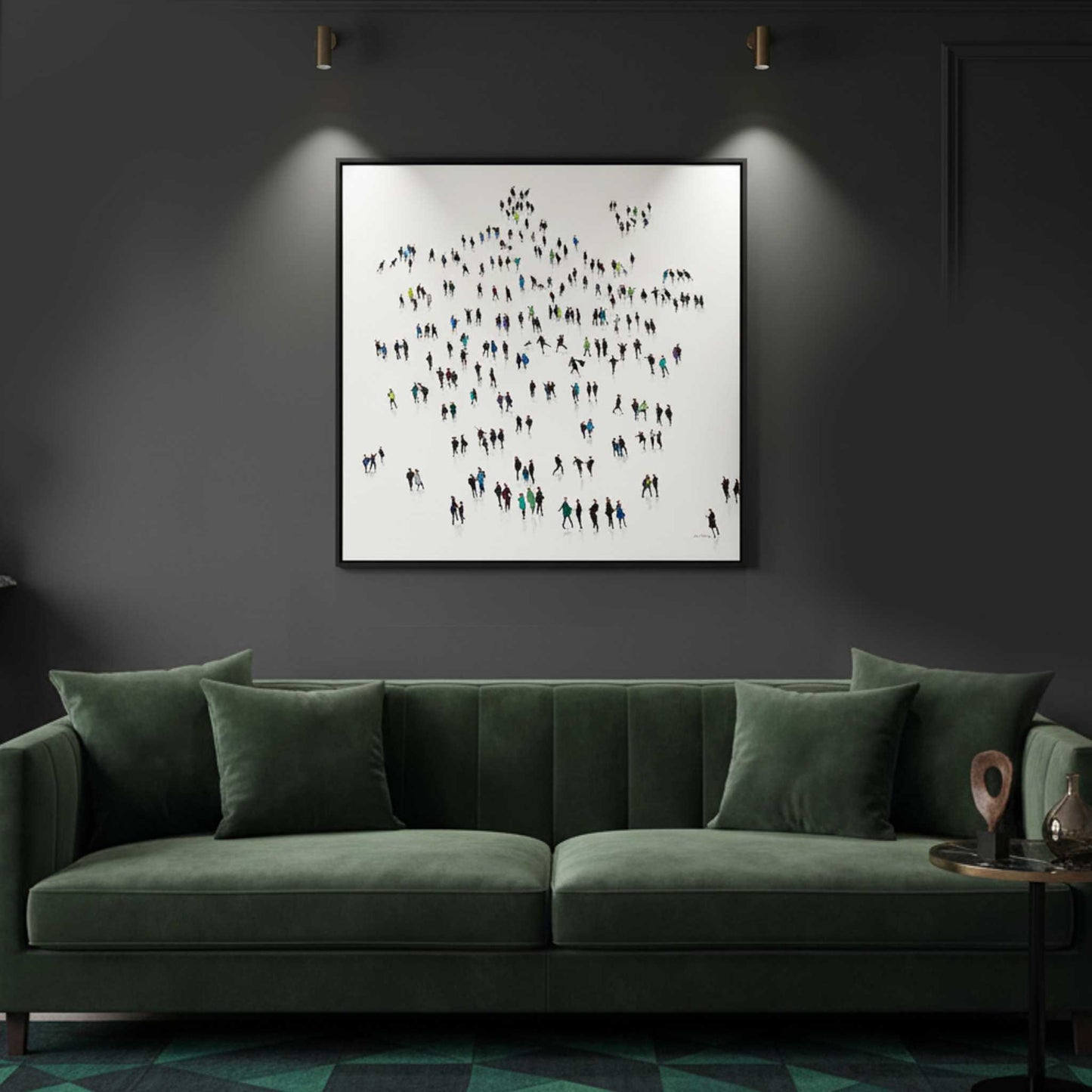 Framed artwork of people on a wall above a green sofa in a dimly lit room.