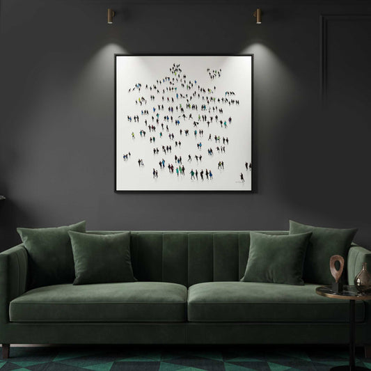 Framed artwork of people on a wall above a green sofa in a dimly lit room.