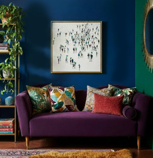 Painting titled Green Protest displayed in the corner of a bright multi coloured room with a purple sofa.