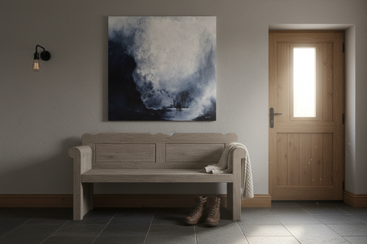 Passing Through Again - a 91cm square painting on canvas depicting a grey mountainous landscape of trees and a lake with an added group of people barely visible in the bottom left corner. The canvas is artfully placed above a wooden settle in a modernised hallway.